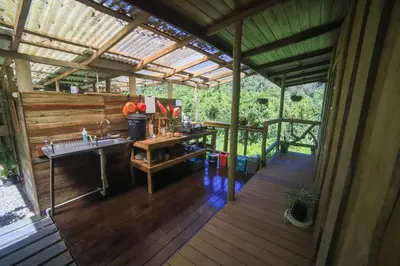a house with a sink and a wooden deck at Preciosa Cabaña de Montaña in Turrialba