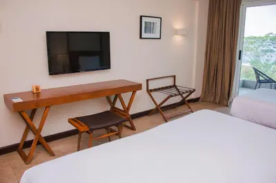 a hotel room with a desk and a television at Wyndham Tamarindo in Tamarindo