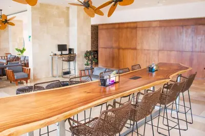a large wooden bar in a lobby with chairs at Wyndham Tamarindo in Tamarindo