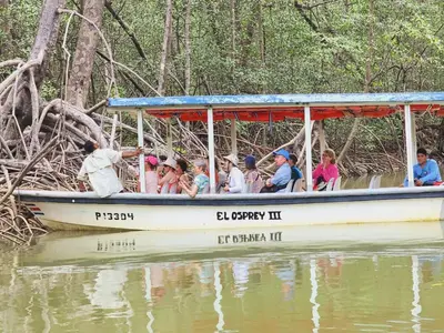 a group of people riding in a boat on the water at Mangrove boat tour lalo it is just a tour in Quepos
