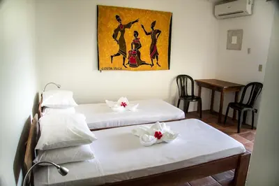 a room with two beds and a table with chairs at Hotel Horizontes de Montezuma in Montezuma
