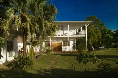a white house with palm trees in front of it at Hotel Horizontes de Montezuma in Montezuma