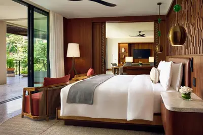 a bedroom with a large bed and a living room at Nekajui Peninsula Papagayo, a Ritz-Carlton Reserve in Papagayo, Guanacaste