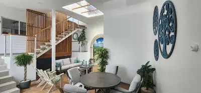 a living room with a table and chairs and a staircase at Stylish Oasis Retreat with Modern Amenities & Scenic Views in San Rafael