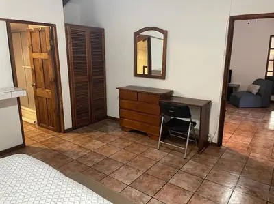 a bedroom with a desk and a mirror and a chair at Sea view Apartment in Puerto Limón