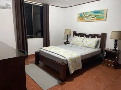 a bedroom with a bed and two lamps and a window at Sea view Apartment in Puerto Limón