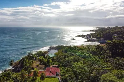 an aerial view of a house on a hill next to the ocean at Sea view Apartment in Puerto Limón