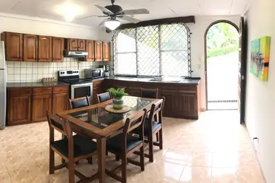 a kitchen with a wooden table and chairs and a dining room at Ocean view Apartment in Puerto Limón