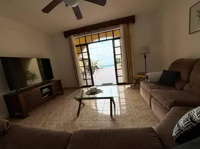 a living room with a couch and a table and a window at Ocean view Apartment in Puerto Limón