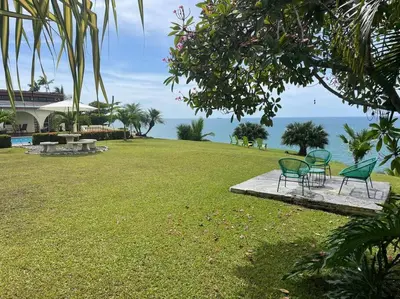a group of chairs sitting on a grass field at Ocean view Apartment in Puerto Limón