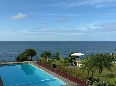 a swimming pool with the ocean in the background at Coral view Apartment in Puerto Limón