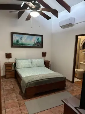 a bedroom with a bed and a ceiling fan at Coral view Apartment in Puerto Limón