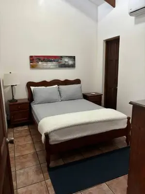 a bedroom with a bed and two nightstands at Coral view Apartment in Puerto Limón