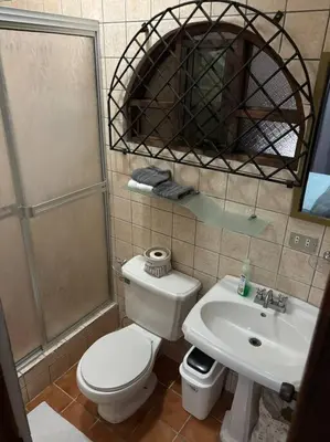 a bathroom with a toilet and a sink and a shower at Coral view Apartment in Puerto Limón