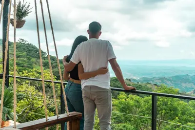 a man and a woman standing on top of a mountain at Golden Sunset Glamping in Monteverde Costa Rica