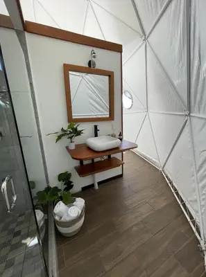 a bathroom with a mirror and a sink in a room at Golden Sunset Glamping in Monteverde Costa Rica