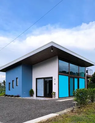 a blue and white building with large windows at Casa Tigrillo - La Fortuna in Agua Azul