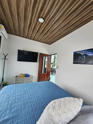 a bedroom with a blue bed with a wooden ceiling at Casa Tigrillo - La Fortuna in Agua Azul