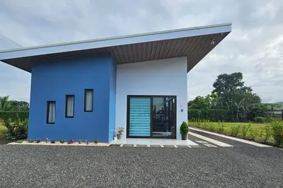 a blue and white house with a large door at Casa Tigrillo - La Fortuna in Agua Azul