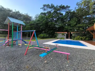 a group of playground equipment next to a swimming pool at Casa Tigrillo - La Fortuna in Agua Azul