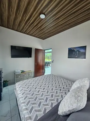 a bedroom with a bed with a wooden ceiling at Casa Tigrillo - La Fortuna in Agua Azul