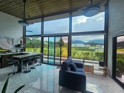 a living room with a couch and a table at Casa Tigrillo - La Fortuna in Agua Azul