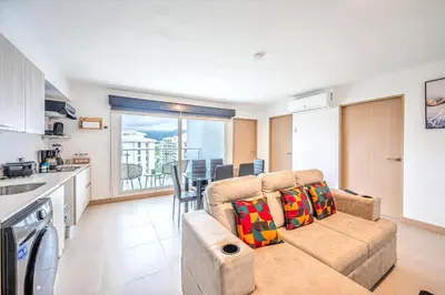 a living room with a couch and a kitchen at Viva Jaco 1305 in Jacó