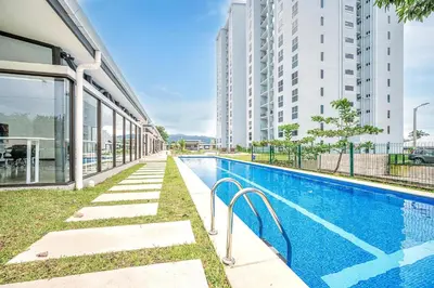 a swimming pool next to a building with tall buildings at Viva Jaco 1305 in Jacó