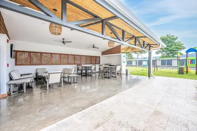 a dining room with chairs and tables in a building at Viva Jaco 1305 in Jacó