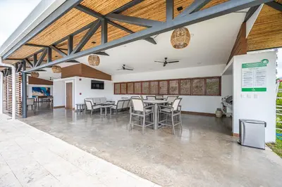 a dining area with tables and chairs in a building at Viva Jaco 1305 in Jacó
