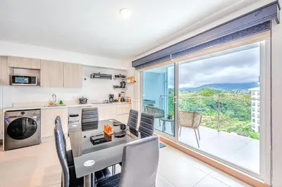 a kitchen with a table and chairs and a large window at Viva Jaco 1305 in Jacó