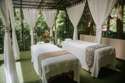 two beds in a room with curtains at Vista Suites at Parador - Adults Only in Manuel Antonio
