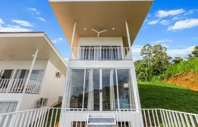 a large white house with a large balcony at Casa amor del sol apartment # 2 in Quebrada Ganado