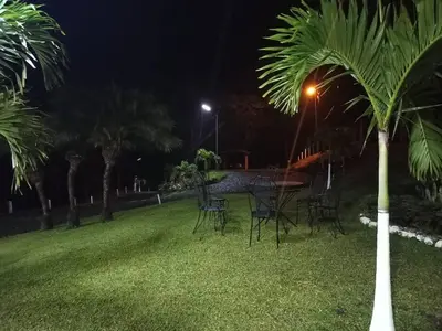 a table and chairs in a park at night at Hospedaje Rancho mi Tata in Solania