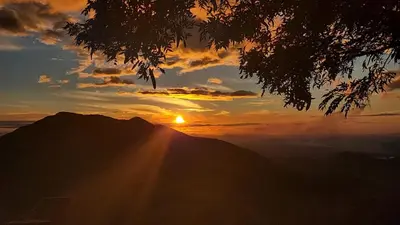 a sunset on top of a mountain with the sun setting at Hospedaje Rancho mi Tata in Solania
