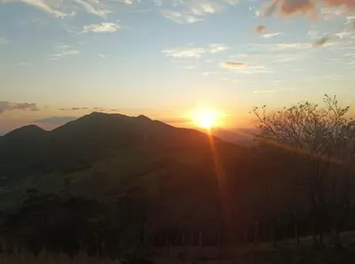 a sunset over a mountain with the sun setting at Hospedaje Rancho mi Tata in Solania
