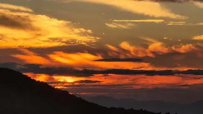 a sunset over a hill with a mountain at Hospedaje Rancho mi Tata in Solania