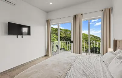 a bedroom with a bed and a large window at casa amor del sol apartment #1 in Quebrada Ganado