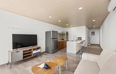 a living room with a couch and a kitchen at casa amor del sol apartment #1 in Quebrada Ganado