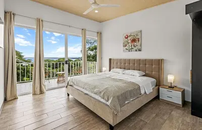 a bedroom with a bed and a large window at casa amor del sol apartment #1 in Quebrada Ganado