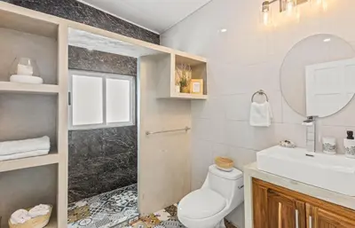 a bathroom with a toilet and a sink and a mirror at casa amor del sol apartment #1 in Quebrada Ganado