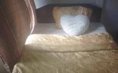 a white heart pillow sitting on a bed at Puertohumo in Puerto Humo