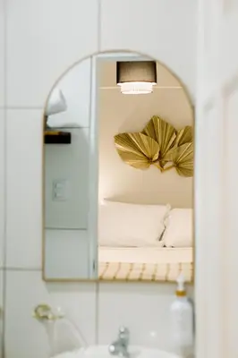 a mirror above a sink with a bed in a room at Hotel VillaFlores in Quesada
