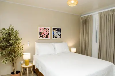 a bedroom with a white bed and a potted plant at Hotel VillaFlores in Quesada