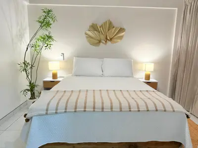 a bedroom with a large bed with two lamps at Hotel VillaFlores in Quesada