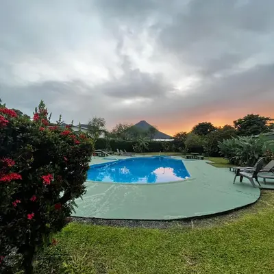 a swimming pool in a yard with a sunset at Hotel Villa Fortuna in Fortuna