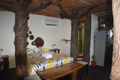 a bedroom with a bed with trees on the wall at Villa Girasol in Sarapiquí