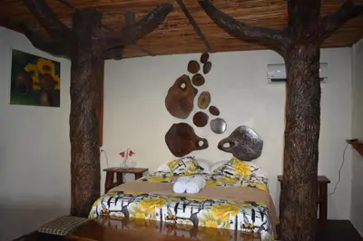 a bedroom with a bed with trees on the wall at Villa Girasol in Sarapiquí