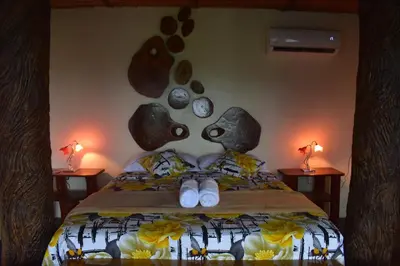a bedroom with a bed with two lamps on two tables at Villa Girasol in Sarapiquí