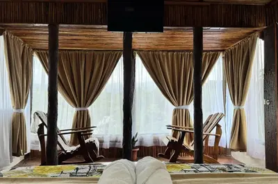a bedroom with two chairs and a large window at Villa Girasol in Sarapiquí